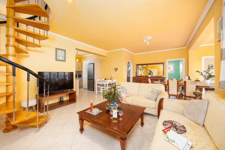 Ground floor: open-plan living room with sofas, dining area, kitchen, A/C, WiFi internet, satellite TV, and sea views