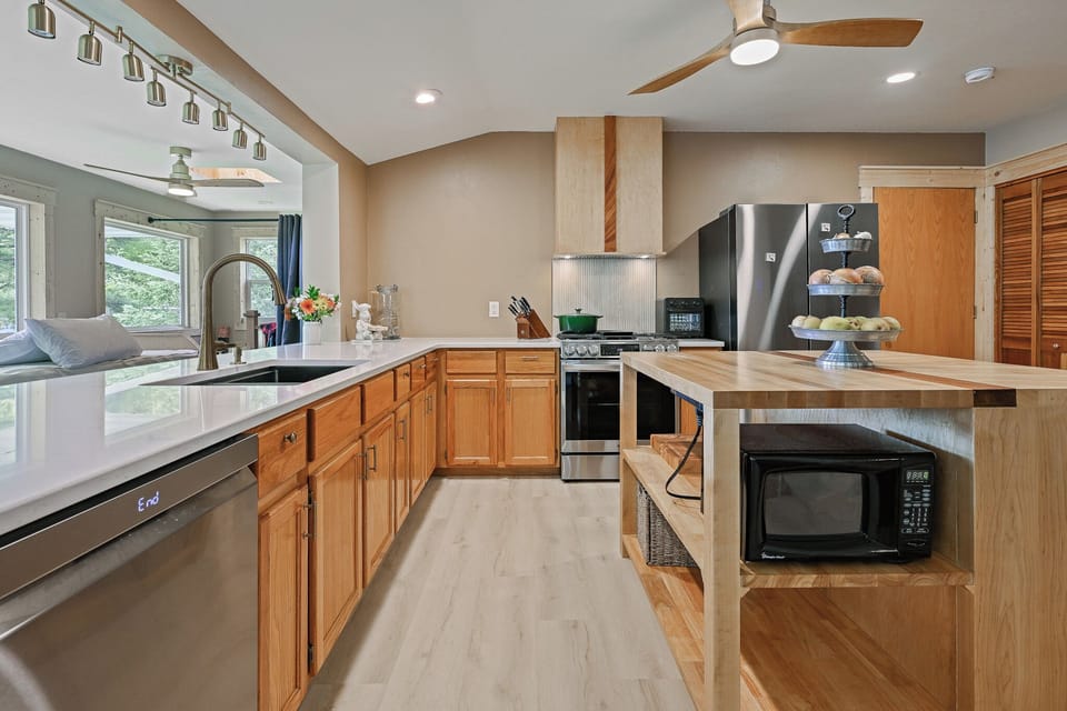 The kitchen is perfectly situated in the center of the upper level.  This allows for meals to be prepared while still allowing you to visit with your family and friends in the dining rooms or on the day beds.  Bonus:  The kitchen also has panoramic lake views!