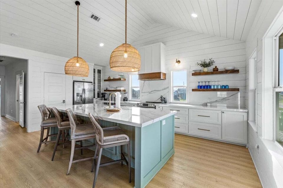 Fully equipped kitchen with large island, seating, and modern appliances