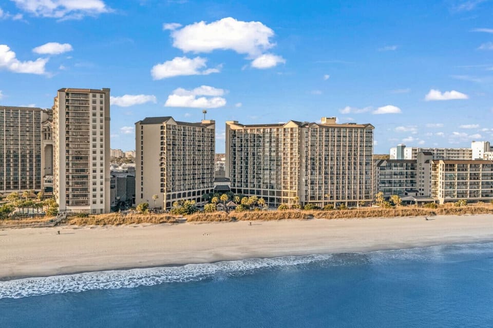 A bird`s-eye look at Beach Cove Resort, perched right along the shoreline with the whole beachfront layout on display.