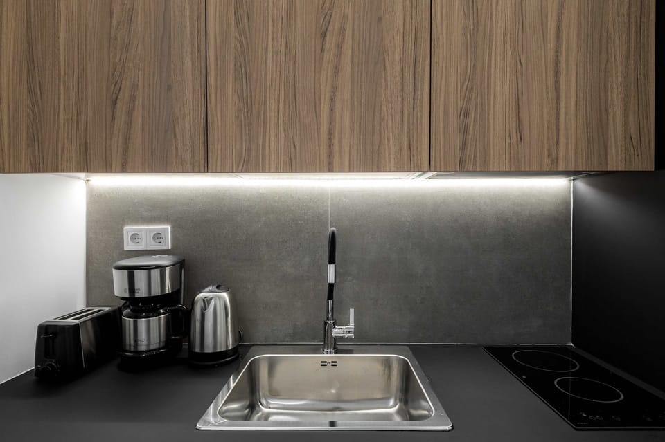 Under-cabinet lighting and streamlined workspace make morning coffee routines smooth and enjoyable.