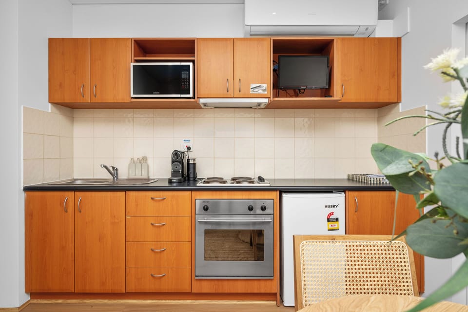 Convenient, functional kitchen with clean wood-toned cabinetry and all essential appliances. 