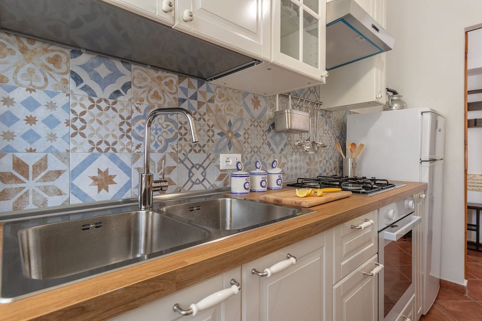 Kitchen: oven, refrigerator, kettle, toaster, moka pot, microwave, dishes.
