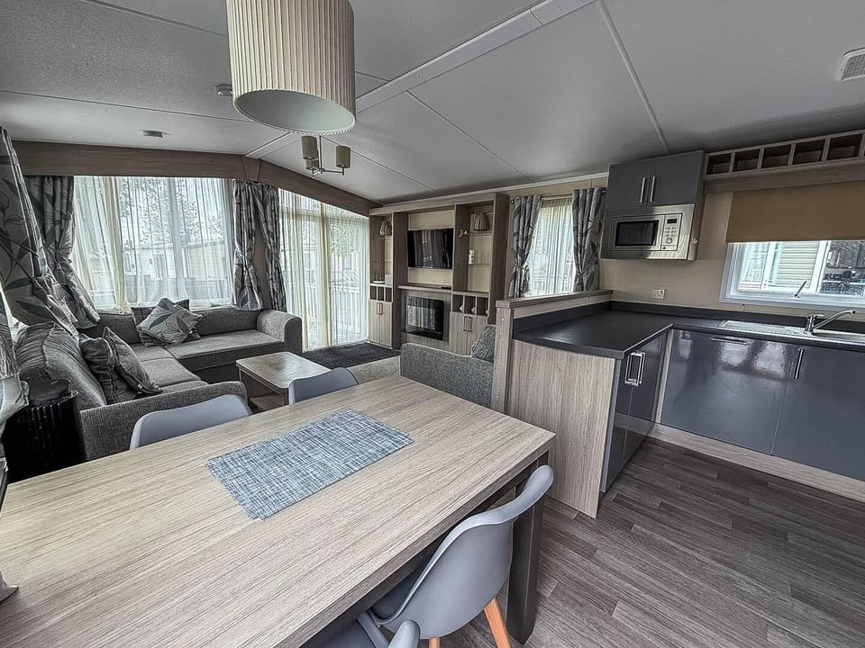 The caravan living room includes a small dining nook and a fold-out sofa for added convenience.