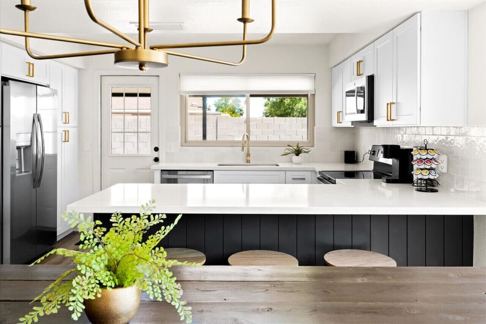 Stunning kitchen with gold accents and a cozy dining setup.
