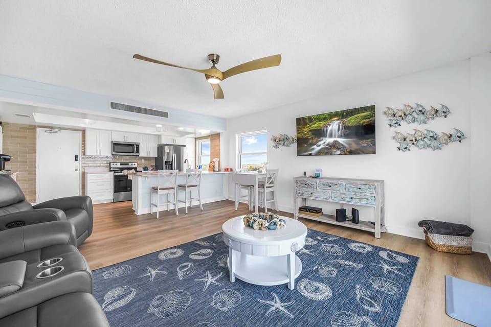 Open-concept living area with coastal decor and a modern kitchen bar.