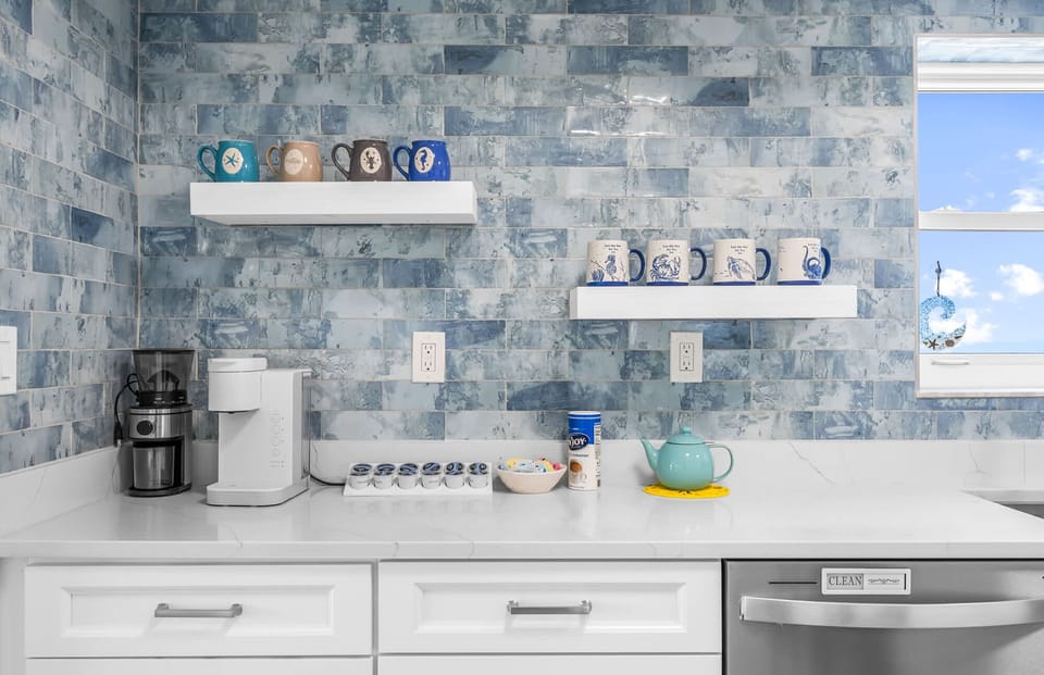 Modern kitchen counter with blue tile backsplash and coffee station