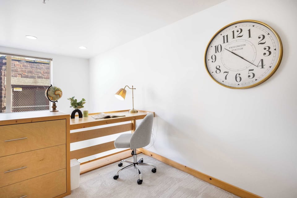 A wooden desk with drawers and a globe—where work gets done without losing that homey calm.