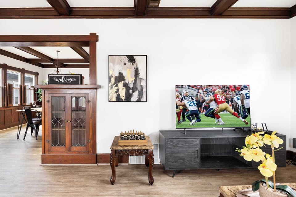 Cozy seating, a smart TV for movie nights, and a board game corner (plus a warm wooden cabinet anchoring the space).