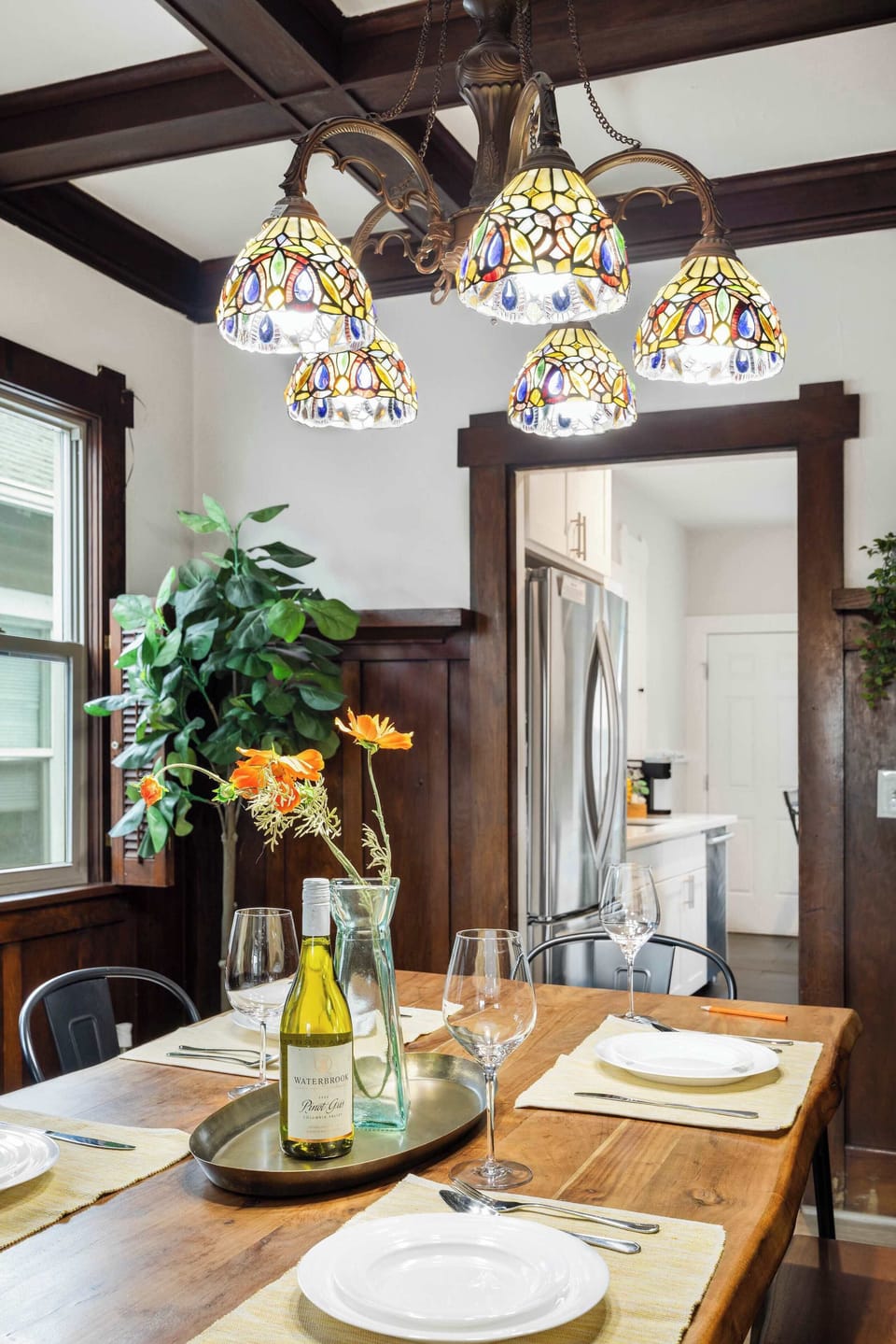 Savor meals in a warm, wood-toned haven—natural textures meet soft chandelier glow.