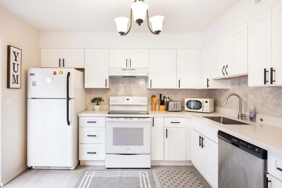 Spacious kitchen area featuring a stylish backsplash, high-end appliances, and a well-equipped counter with everything you need to enjoy your stay.
