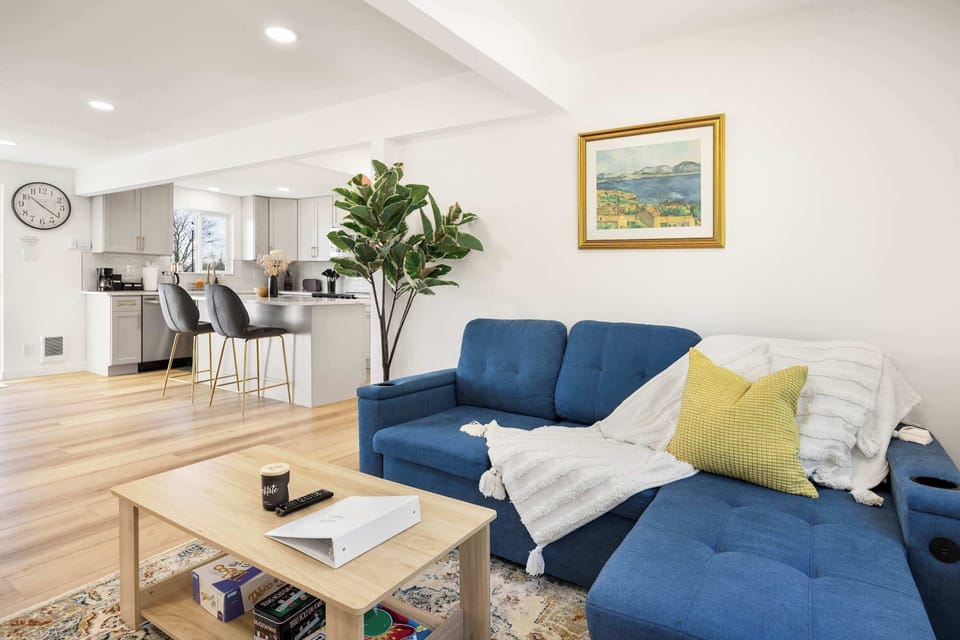 A stylish blue sectional with soft throws and pillows invites you to relax. Whether watching TV, playing games, or enjoying a quiet evening, this space is designed for comfort.