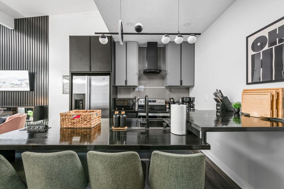 Welcome to our modern moody kitchen with 4 bar stools, upgraded appliances, and a stylish, eclectic vibe.
