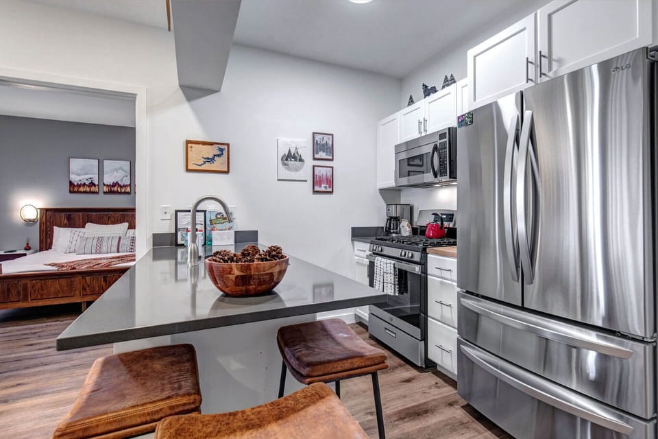 Your sleek modern kitchen features granite countertops, stainless steel appliances, and a breakfast bar perfect for morning coffee or evening snacks.