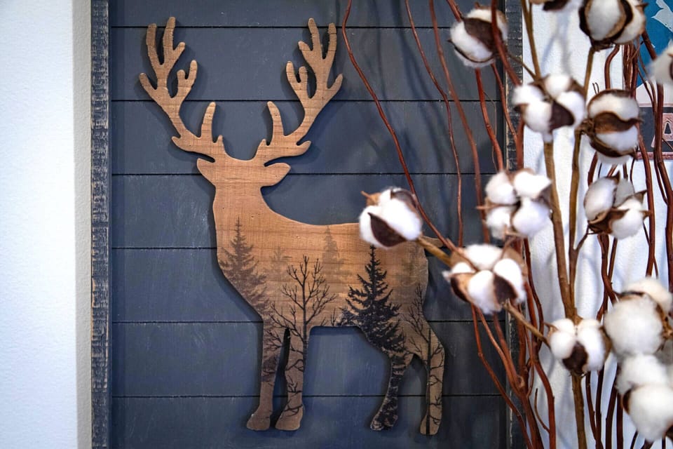 Rustic charm welcomes you with handcrafted woodland art and soft cotton stems that create your perfect cozy retreat atmosphere.