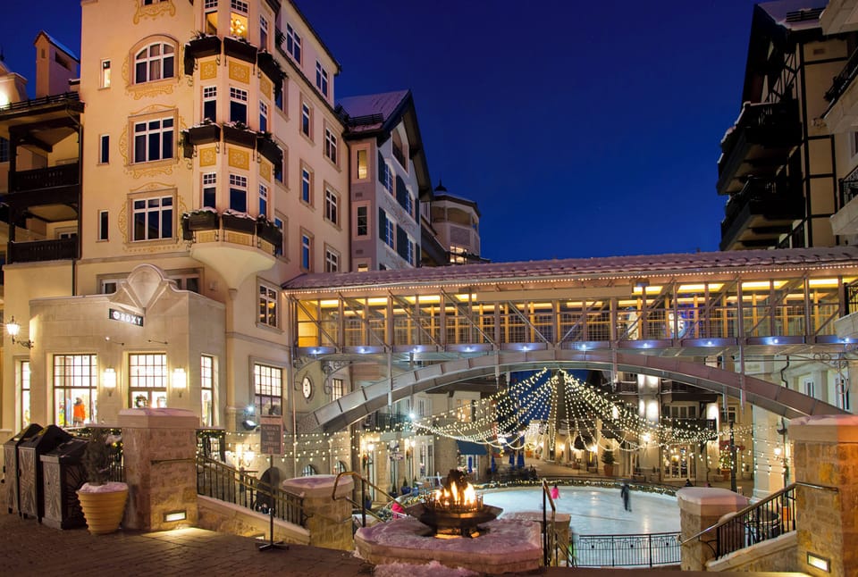 Located in Lionshead Village,with festive lights, an ice rink under a bridge, and a cozy fire pit creating a warm winter atmosphere.