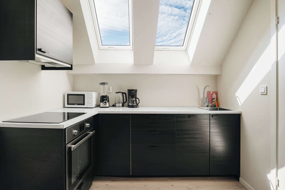 Fully equipped kitchen featuring sleek cabinetry and bright natural light.