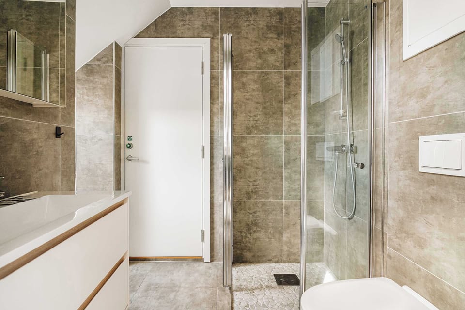 Elegant bathroom with polished concrete tiles and premium fixtures.