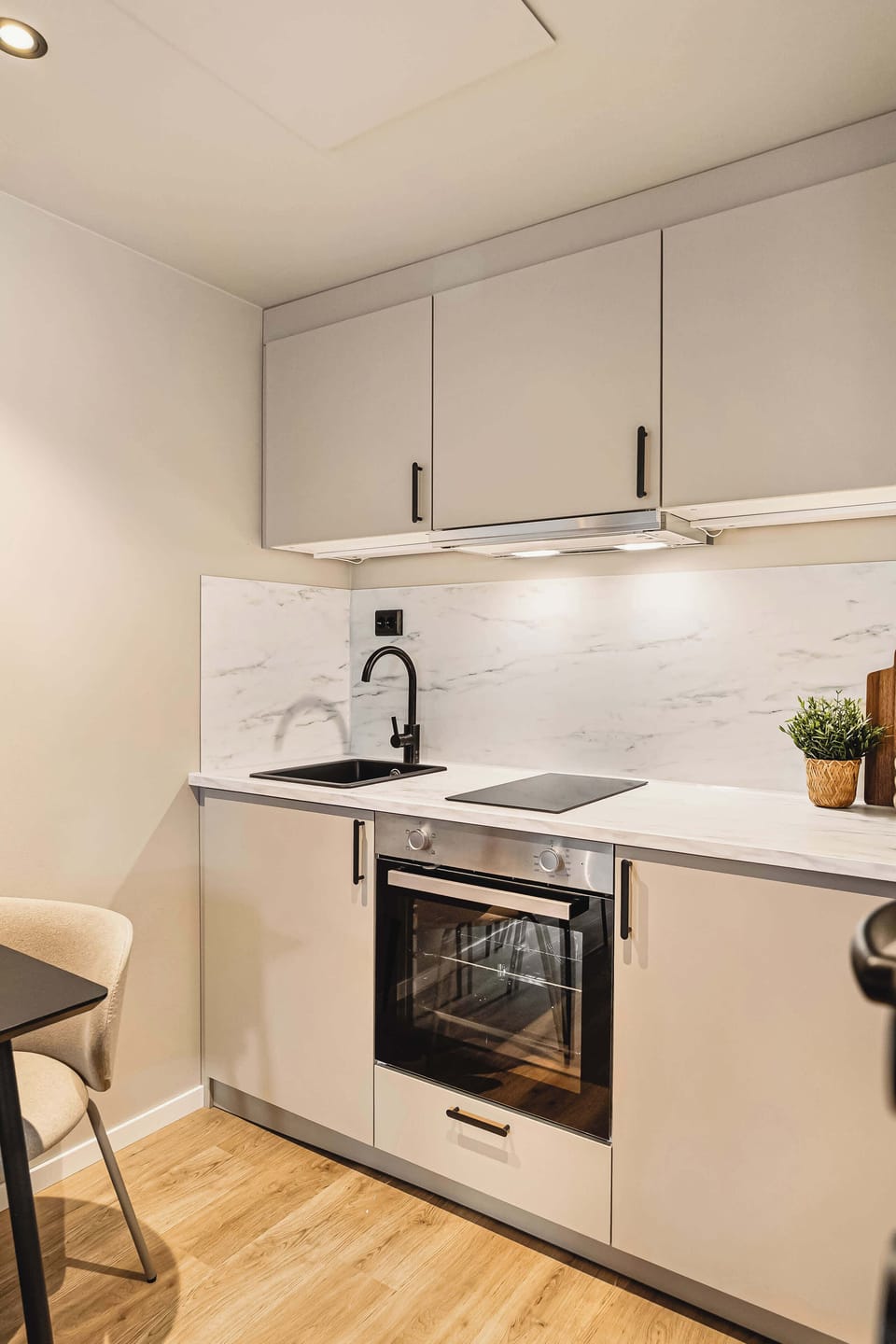 Modern kitchenette fully equipped with oven, stovetop, and sleek cabinetry