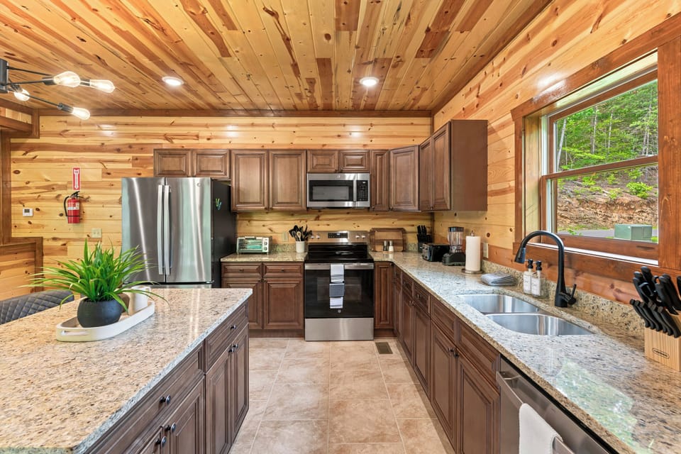 Fully equipped chef’s kitchen with granite countertops and bar seating.