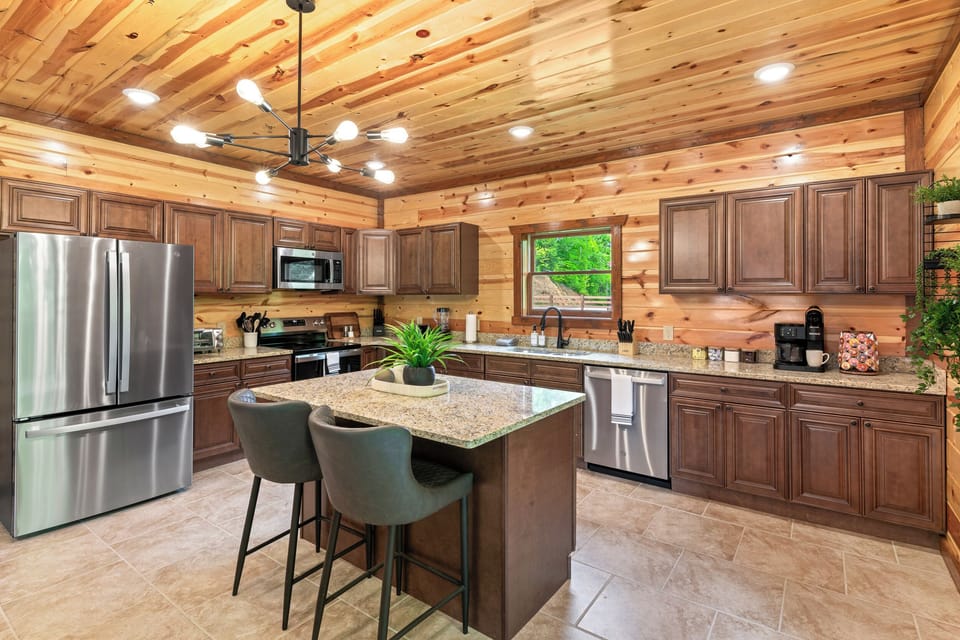Fully equipped chef’s kitchen with granite countertops and bar seating.