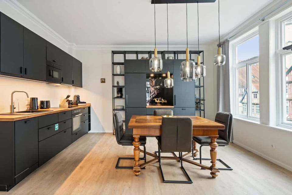 Moderne Einbauküche mit Holzarbeitsplatte - 
In der stilvollen Küche mit dunklem Design und Holzarbeitsplatte findest Du alles, was Du zum Kochen brauchst – von Ceranfeld bis Mikrowelle.