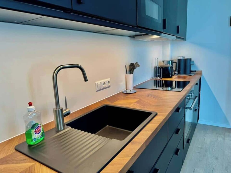 Voll ausgestattete Küche für Selbstversorger - 
Bereite Dir in der eleganten Designküche mit Cerankochfeld, Toaster und Wasserkocher ganz einfach Deine Lieblingsgerichte zu.