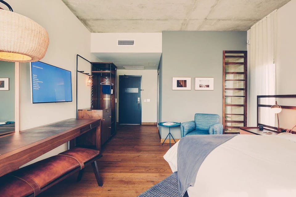 Lounge in airy modern style with desk, TV, and seating.
