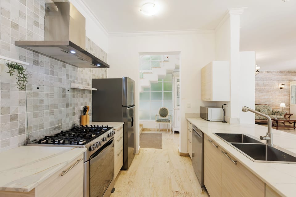 Bright kitchen with gas stove, fridge, and coffee station