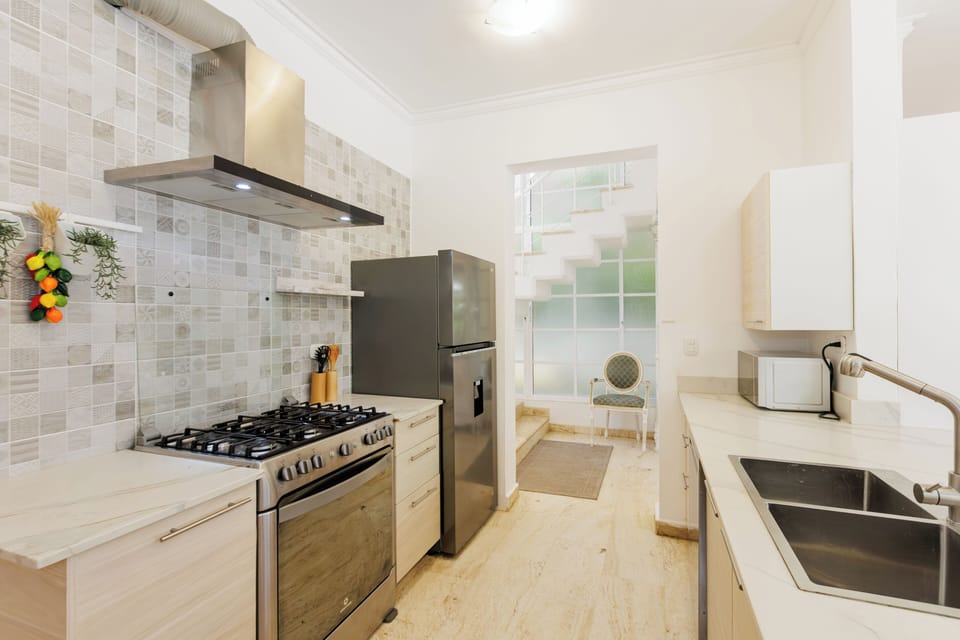 Bright kitchen with gas stove, fridge, and coffee station