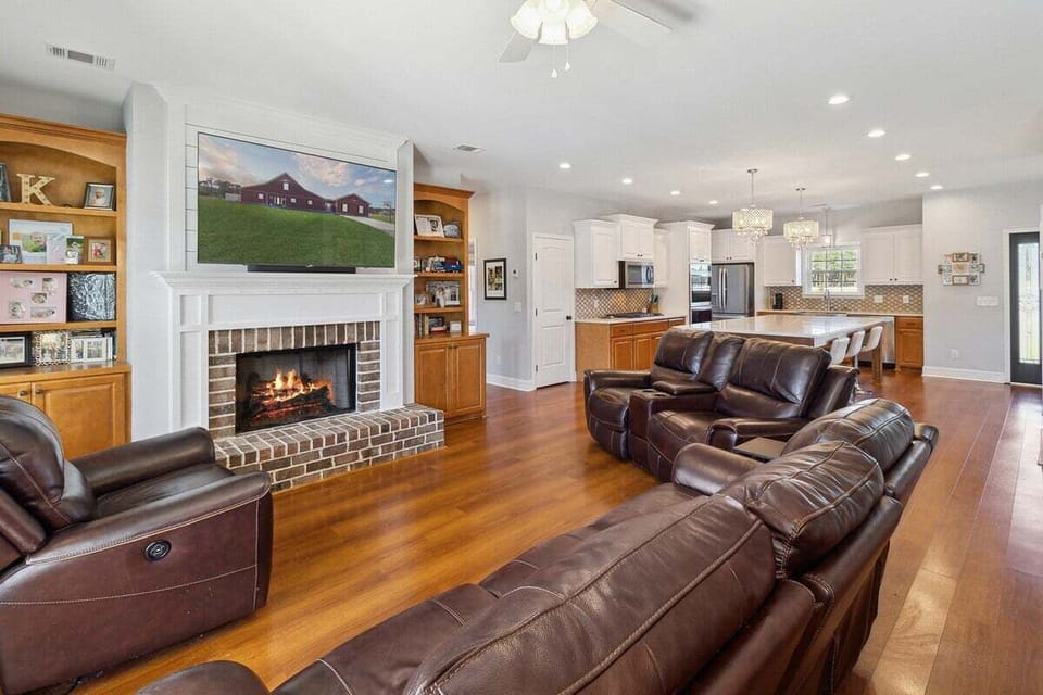 Spacious living room with 5 electric recliners, a cozy gas fireplace, and a 65" Roku TV—comfort and movie nights made easy!
