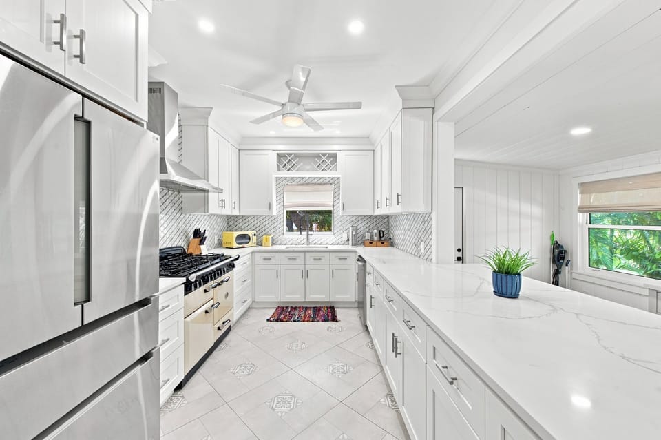 Fully equipped kitchen with white cabinetry and modern appliances