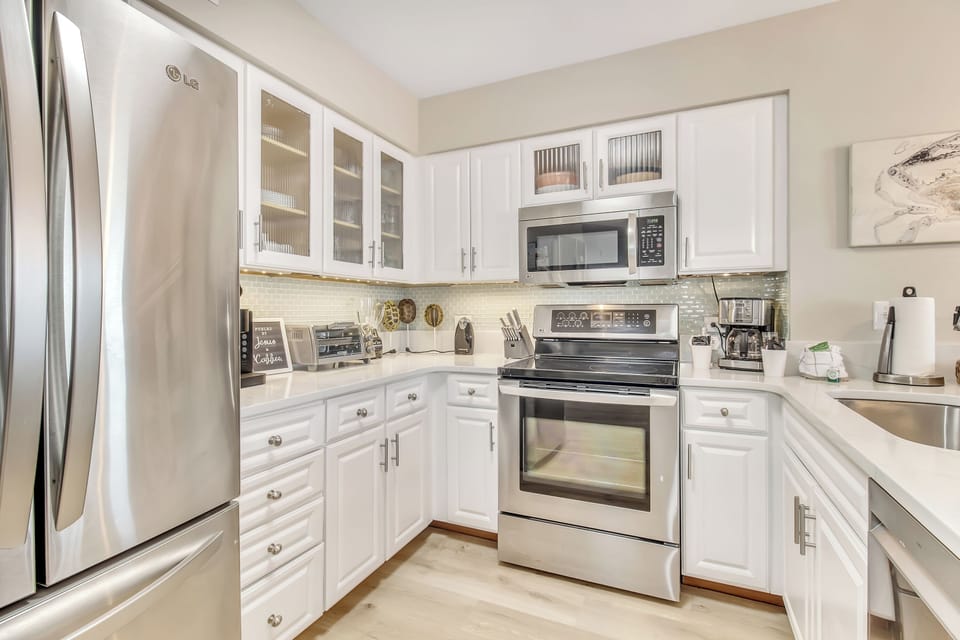 Your bright kitchen features crisp white cabinets, stainless steel appliances, and elegant quartz countertops perfect for preparing meals during your stay.