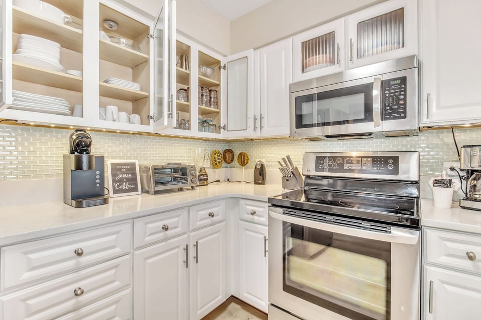 Your fully equipped gourmet kitchen awaits with gleaming white cabinetry, granite counters, and premium appliances perfect for creating memorable meals.