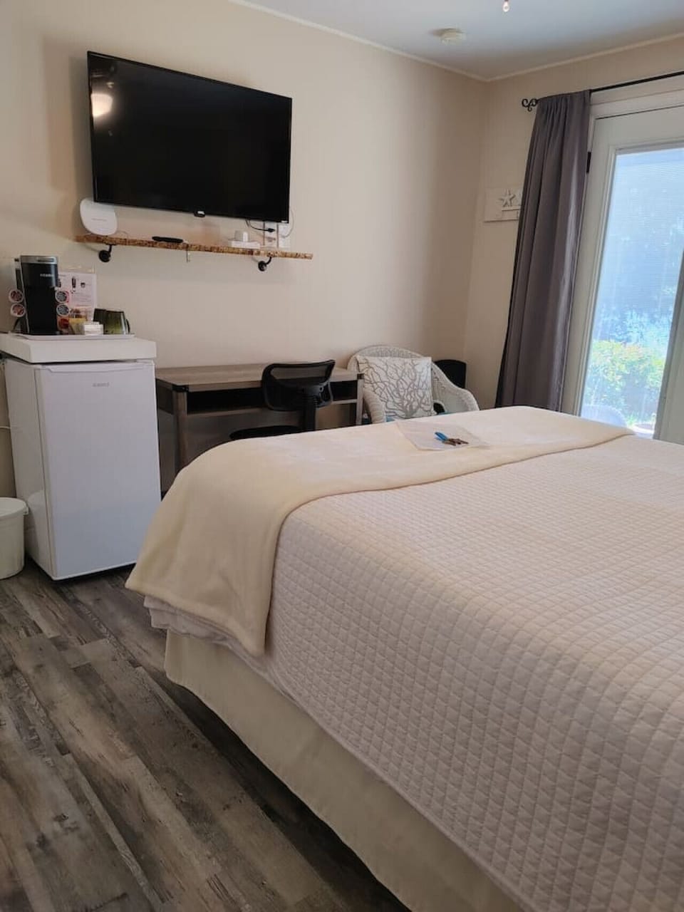 Room set up with workspace, mini fridge, keurig coffee/tea station, Roku TV