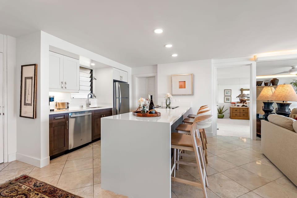 The gourmet kitchen is thoughtfully designed for connection and convenience, with full-size appliances, sleek countertops, and a central island perfect for prepping meals or hosting friends.