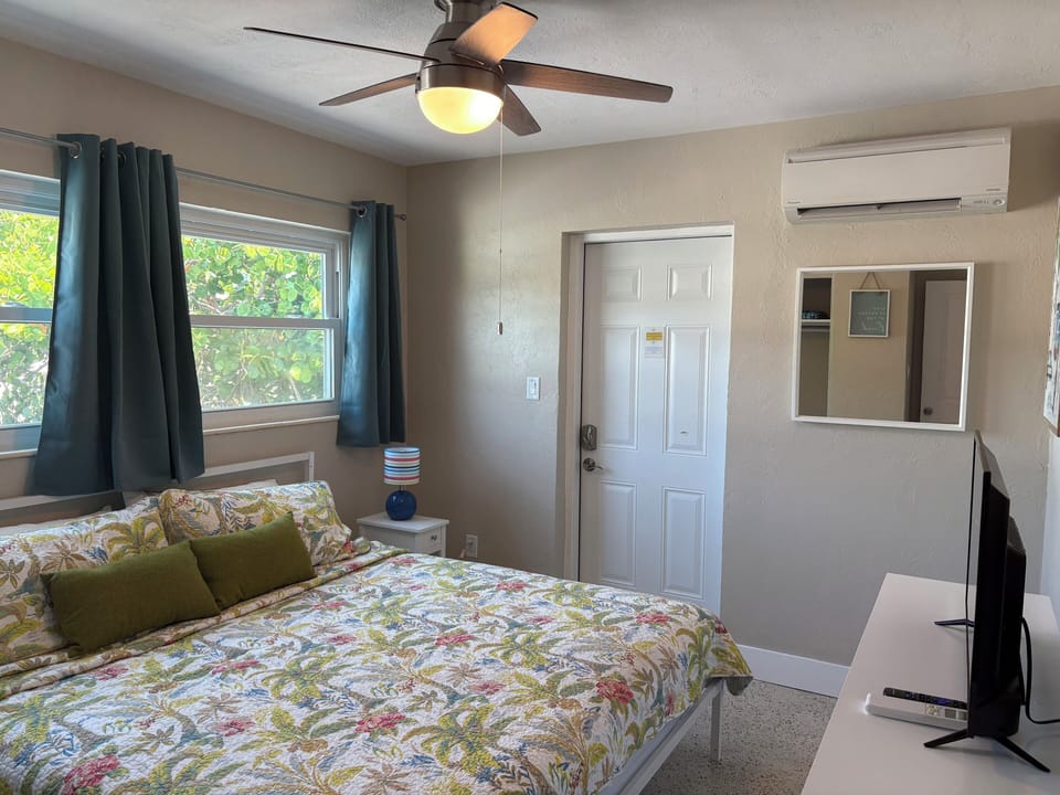 Bedroom 1 with king bed and sheets, exterior door 