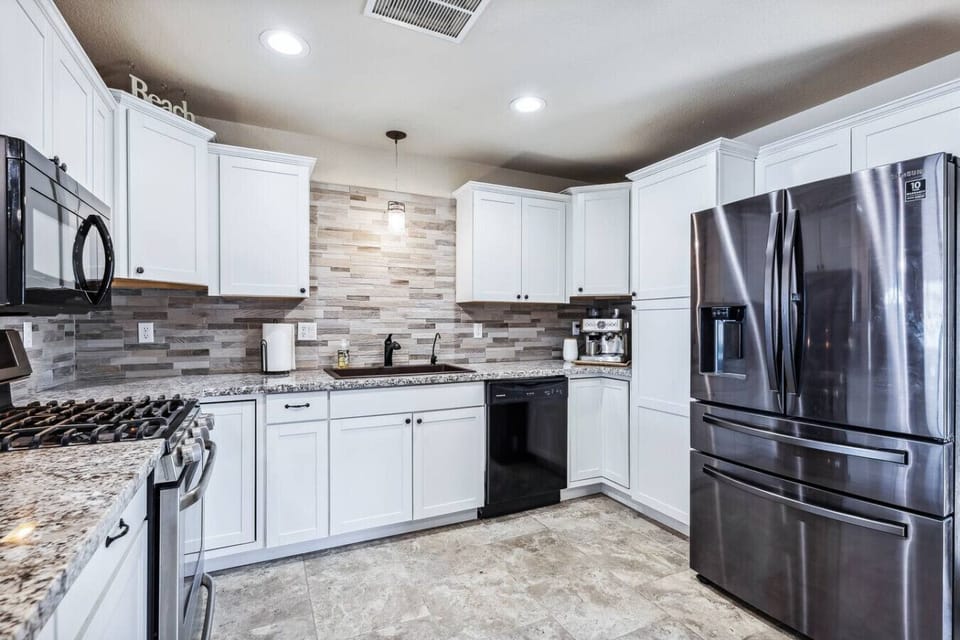Fully equipped kitchen with stainless steel appliances — plus barstool seating at the counter.