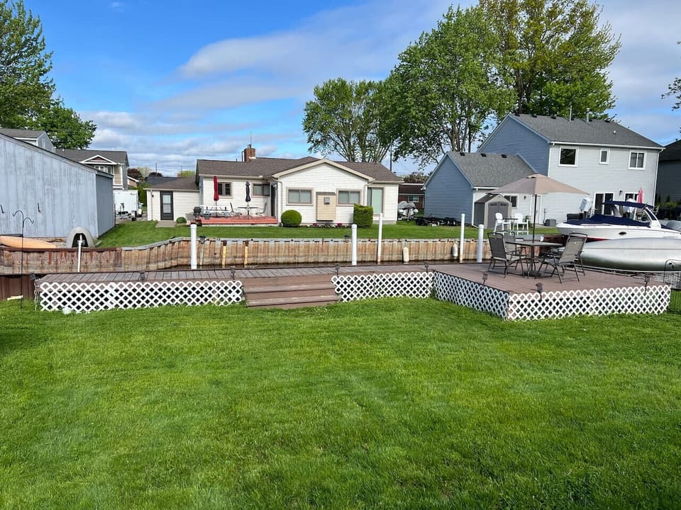 The back yard as seen from the back door. Plenty of green grass for kids to play (or adults).  Or take a seat and enjoy your coffee or meals on the deck.