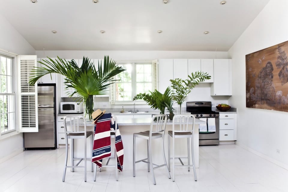The kitchen has a central island with stools, ideal for keeping the cook company.