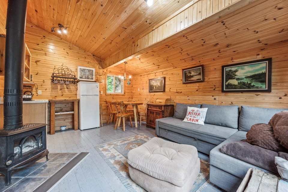 Enjoy hearty meals at the pine dining table or sink into the plush sectional after a day of hiking. With cabin art and warm wood paneling, the space feels authentically rustic and relaxing.