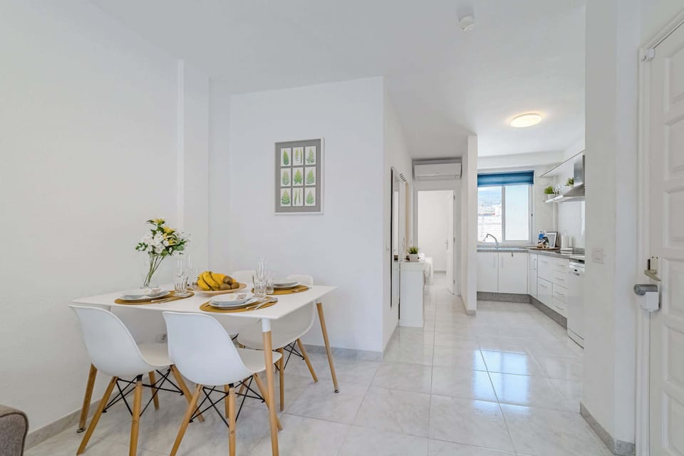 Open-Concept Living Area with a Dining Table, Sofa-Bed, Smart TV, AC & Plenty of Natural Light. 