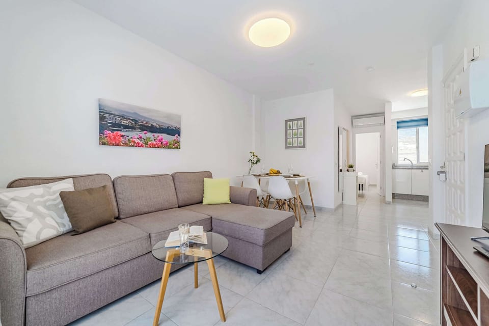 Open-Concept Living Area with a Dining Table, Sofa-Bed, Smart TV, AC & Plenty of Natural Light. 