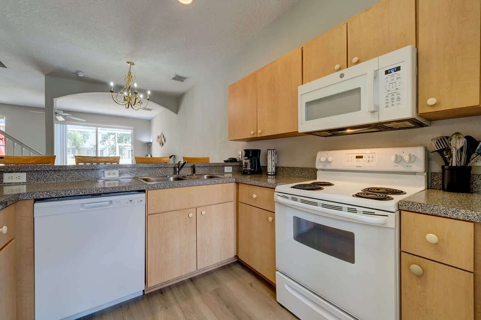 Modern kitchen with light wood cabinets and white appliances