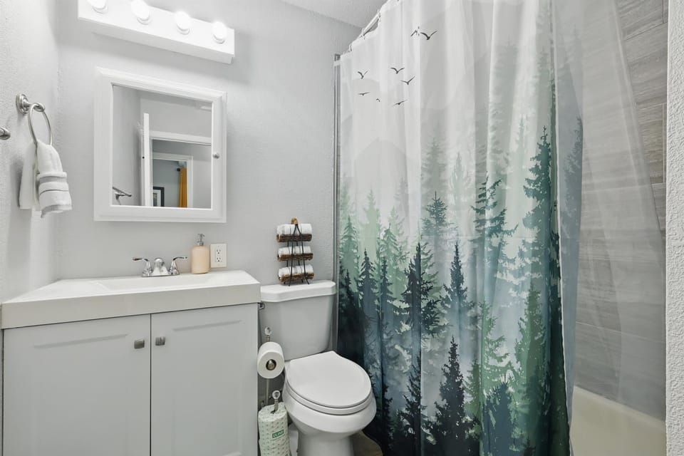 A clean, bright bathroom equipped with essential toiletries and everything you need — including a bathtub for a quick rinse or a relaxing bubble bath.