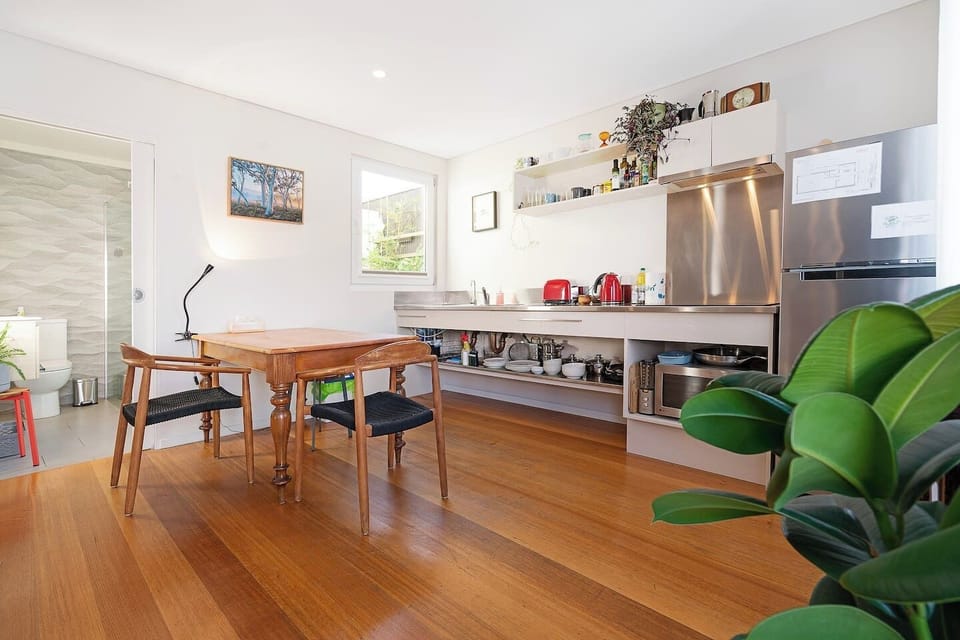 Enjoy relaxed meals at the antique timber table, just steps from the efficient kitchen and the modern bathroom.