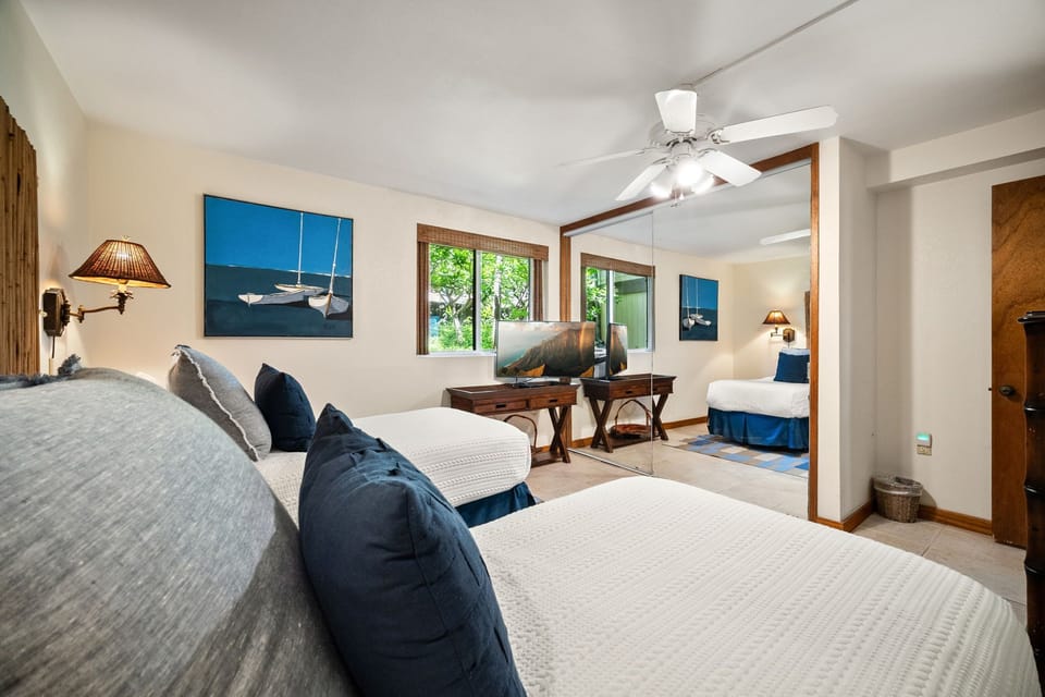 Sink into plush bedding in this light-filled retreat, where coastal artwork sets a serene tone. Your peaceful sanctuary flows into a cozy sitting area with garden views just beyond.