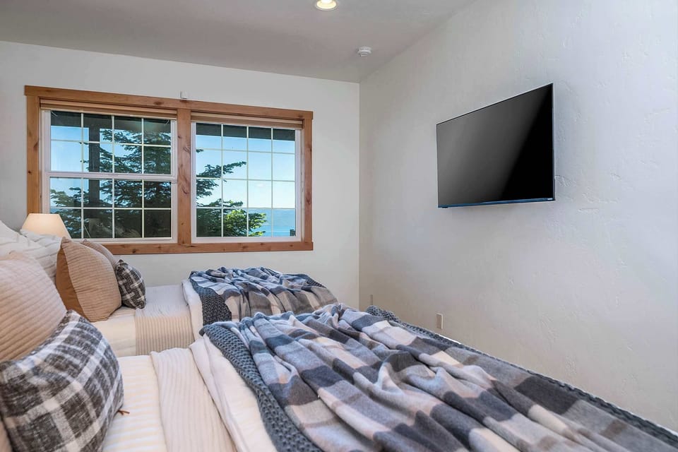 Lower level second bedroom with two queen beds and an ensuite bathroom with a shower-tub combo, a vanity, and a toilet.