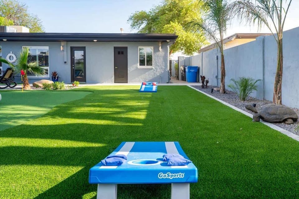Enjoy a friendly game of cornhole on the lush green lawn, perfect for outdoor fun.