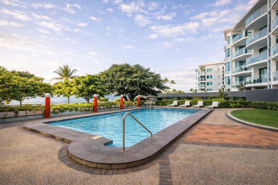 Resort-style swimming pool surrounded by tropical gardens